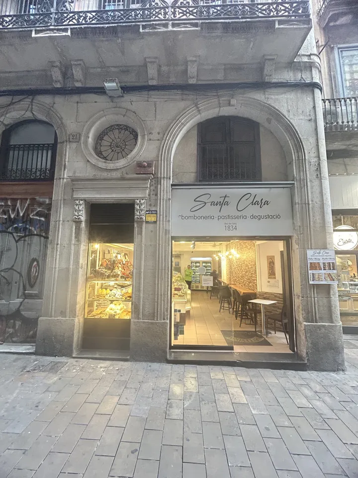 La façana de Santa Clara al carrer de la Llibreteria, amb el rètol «bomboneria · pastisseria · degustació · 1834»